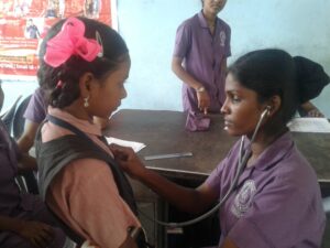 Girl performing stethoscope check on classmate in SSVS-led event